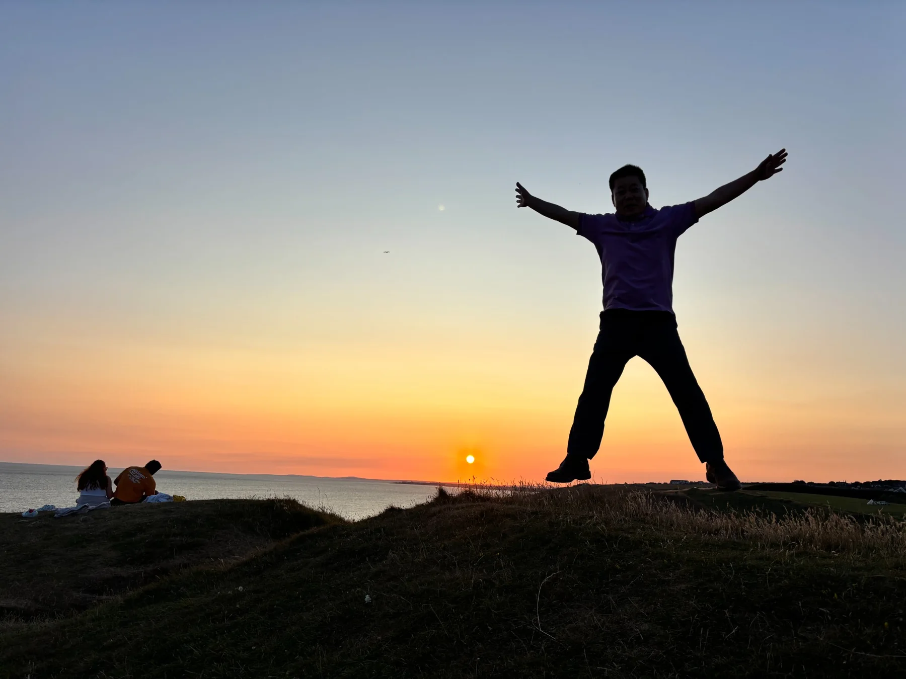 A joyful silhouette at sunset by the sea